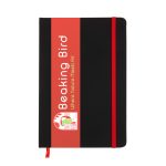 A black A5 notebook with a red elastic band and branding on the front cover.
