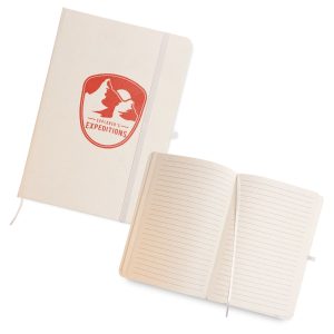 A light-colored A5 notebook with a logo on the cover and lined pages inside. It features an elastic closure.