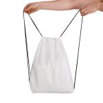A white drawstring backpack being held by a hand, featuring a simple design and black drawstrings.