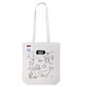 A cotton tote bag in off-white, featuring outlined sea creatures and children, with an attached branding label.