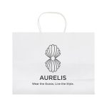 A large white paper bag with a decorative logo design and handles. Features minimalistic branding and text.