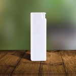 A white spray bottle stands upright on a wooden surface, featuring a simple design and a small nozzle.