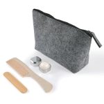 A gray felt cosmetic bag with a zipper, accompanied by a wooden comb, a round cream container, and a silver lid.