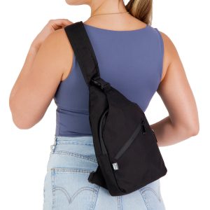 A black sling bag is worn over the shoulder, featuring a zip pocket and adjustable strap.