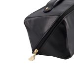 A black toiletry bag with a geometric design and a gold zipper detail, featuring a handle for easy carrying.