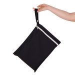 A black wet bag with a white zip, held by a hand, featuring a looped handle for easy carrying.