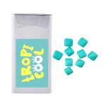 A rectangular package of mints in white, with several turquoise square mints scattered beside it. The package has a logo.