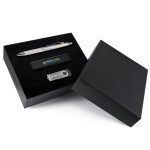 A black gift set containing a silver pen, a USB drive, and a black flash drive, presented in a sleek box.