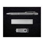 A silver pen, a sleek metal bar, and a silver USB drive arranged on a black background.