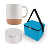 A coffee mug with a cork base, a compact Bluetooth speaker, and a blue insulated carrying bag.