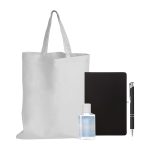 A reusable tote bag, a bottle of hand sanitizer, a black notebook, and a pen.