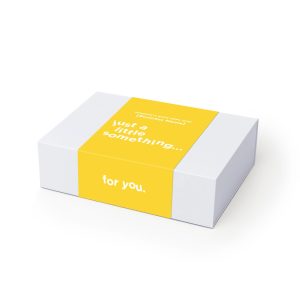 A gift box with a white exterior and a bright yellow band, featuring minimalist text.