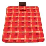 A red and black checkered picnic blanket features a handle for easy carrying and a logo in one corner.