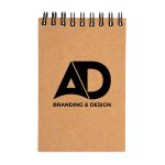 A spiral-bound pocket notebook with a kraft cover featuring the logo "AD" along with the text "BRANDING & DESIGN".