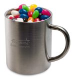 A stainless steel mug filled with assorted colorful mini jelly beans, featuring a branding logo.