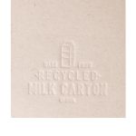 A booklet made from recycled milk cartons, featuring an embossed design that highlights its eco-friendly material.