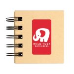 A spiral-bound notebook with a kraft cover featuring a white elephant logo and the text "WILD TUSK DEFENDERS."