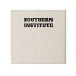 A square, off-white note block made from recycled materials, featuring a logo and embossed text.