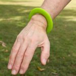 A bright green silicone flyer, designed to be worn as a wrist disc.