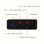A black power bank with multiple USB outputs, LED battery indicator, and power button. Features two USB-A and two Type-C ports.
