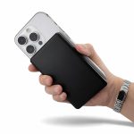 A black power bank held in one hand, with a smartphone in the other. The background is plain.