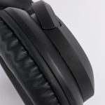 Black headphones with cushioned ear pads and a sleek design, featuring a branding logo on the side.