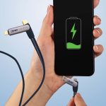 A charging cable with a dark blue fabric finish, connected to a smartphone displaying a battery icon.