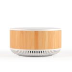 A round speaker and wireless charger with a bamboo timber exterior and a white base. The product features a logo.