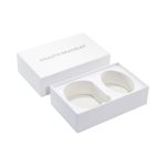 A large white gift box containing two health bracelets, featuring a simple, elegant design.