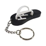 A custom moulded flash drive shaped like a black flip-flop with a white thong and attached keychain.
