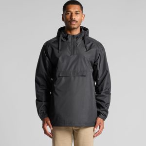 A man wearing a black windbreaker jacket featuring a hood and front pocket. The jacket has a logo on it.
