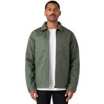 A man wearing a green service jacket over a white t-shirt, standing with a neutral expression. The jacket has a logo.